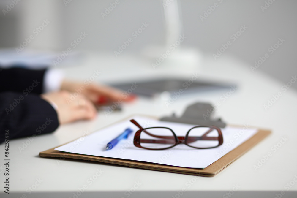 Young woman sitting at the desk with folder Young woman sitting at the desk with folder