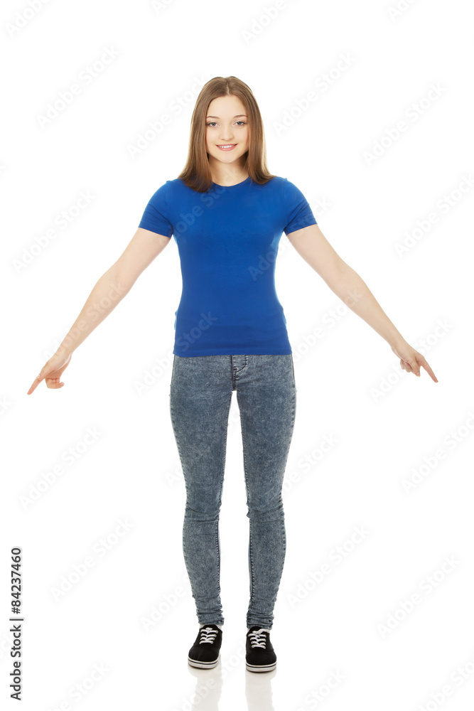 Smiling young woman pointing down. Smiling young woman pointing down.