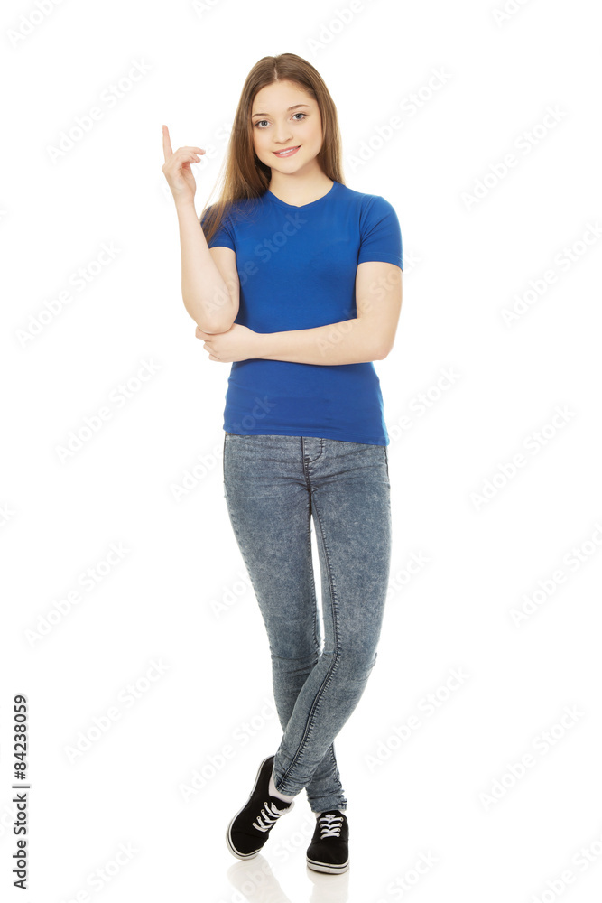 Smiling young woman pointing up. Smiling young woman pointing up.