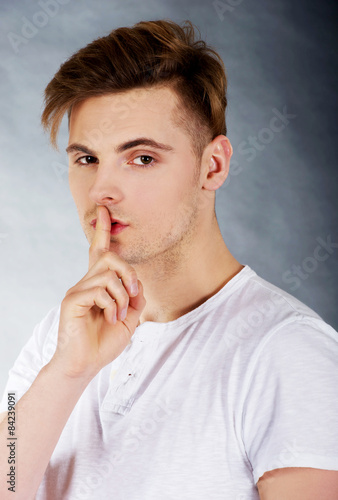 Young man showing silent gesture.