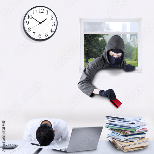Tableau sur toile Burglar stealing credit card in office