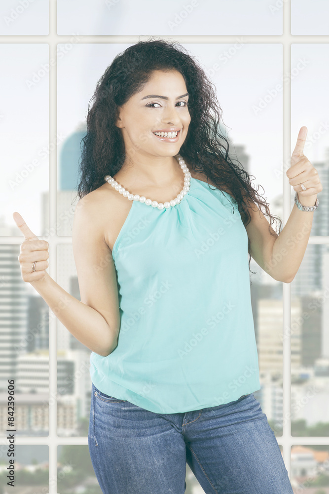 Businesswoman with curly hair shows thumbs up Businesswoman with curly hair shows thumbs up