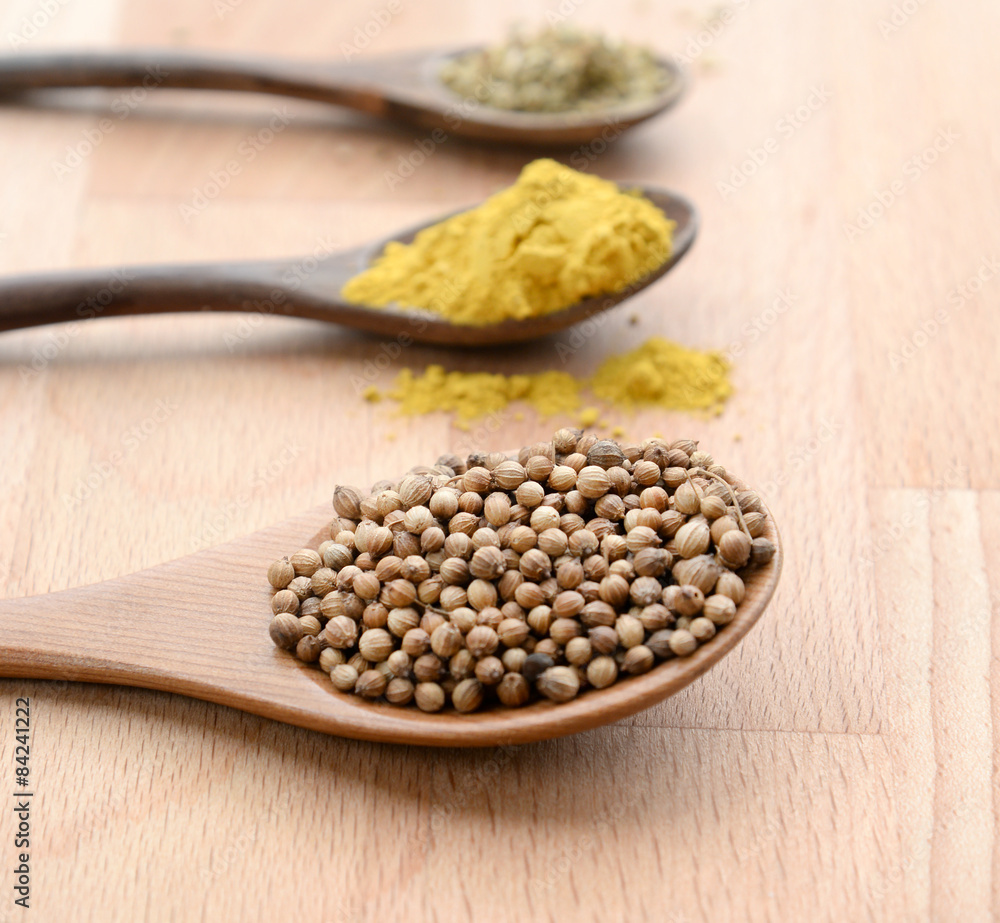 close up of assortment spices in wooden spoons close up of assortment spices in wooden spoons