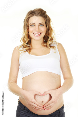 Pregnant woman showing heart by hands on belly  © 5second