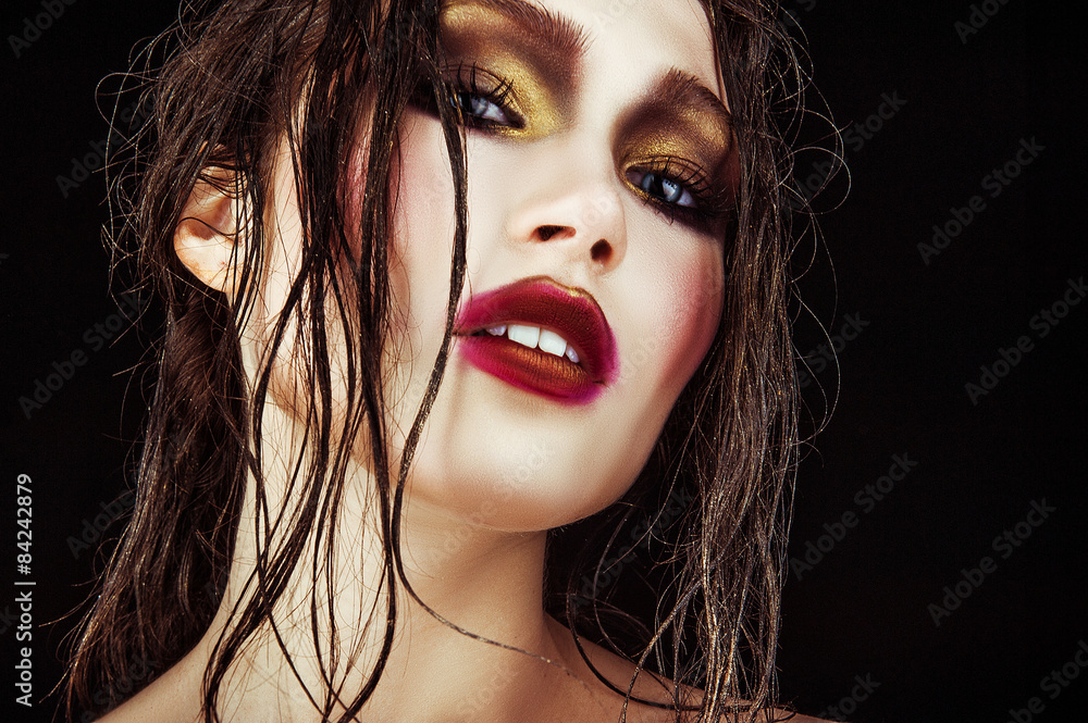 Fototapeta premium sexy woman with gold make-up and wet hair on a black background