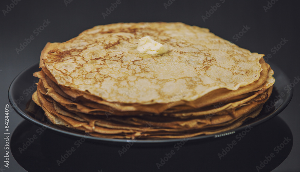 The lot of pancakes on black plate