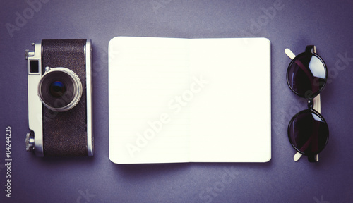 camera and classic notebook with sunglasses