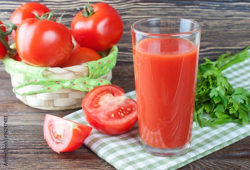 tomato juice and fresh tomatoes on wooden table