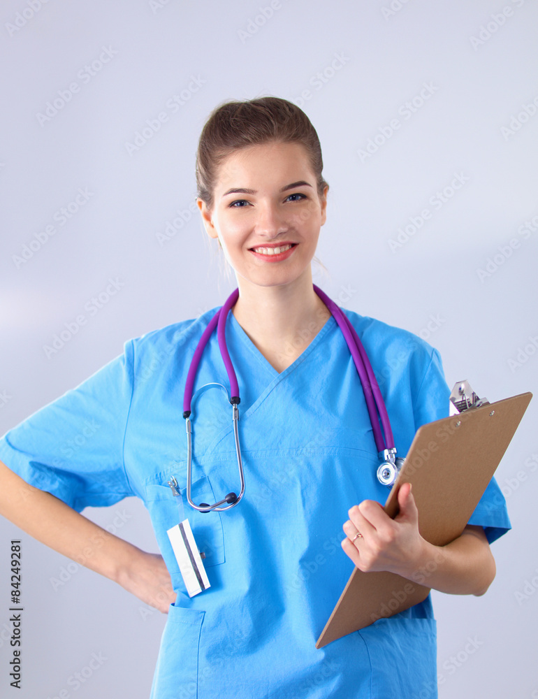 Smiling female doctor with a folder in uniform standing at Smiling female doctor with a folder in uniform standing at