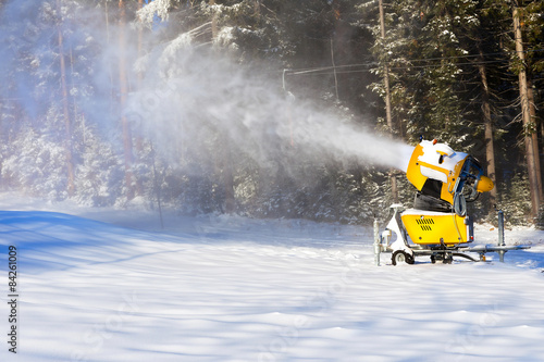 Snow gun on the background of the winter forest