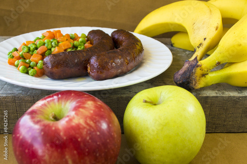 Sausages on a plate and fruits