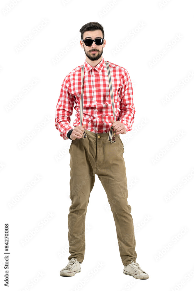 Hipster posing while pulling elastic pants suspenders isolated Hipster posing while pulling elastic pants suspenders isolated