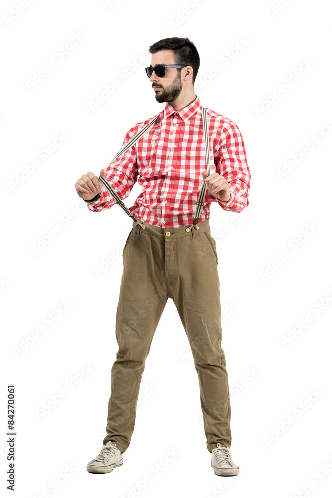 Young hipster pulling suspenders with sunglasses isolated Young hipster pulling suspenders with sunglasses isolated