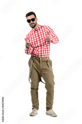 Smiling hipster with finger hand gun gesture aiming at camera