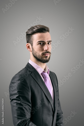 Portrait of mysterious young bearded man in formal wear