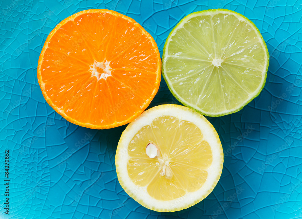 Mandarin, lemon, and green lime slices isolated on blue Mandarin, lemon, and green lime slices isolated on blue