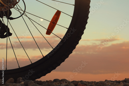 Bike wheel with dawn sky behind