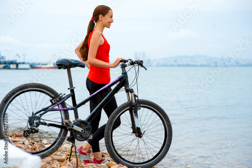 Woman with bicycle on the beach