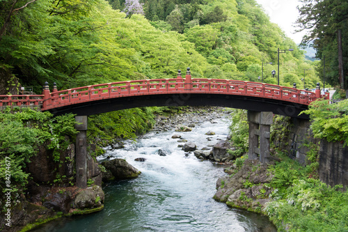 Red Japanese bridge over a mountain stream