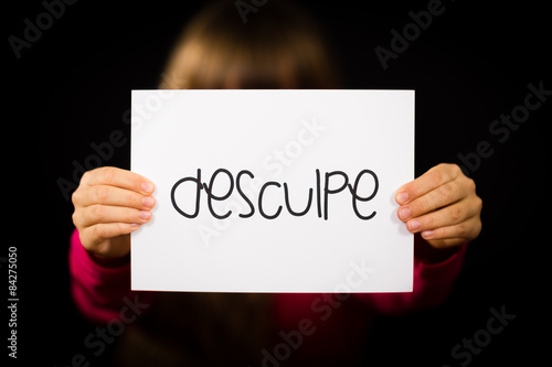 Child holding sign with Portuguese word Desculpe - Sorry