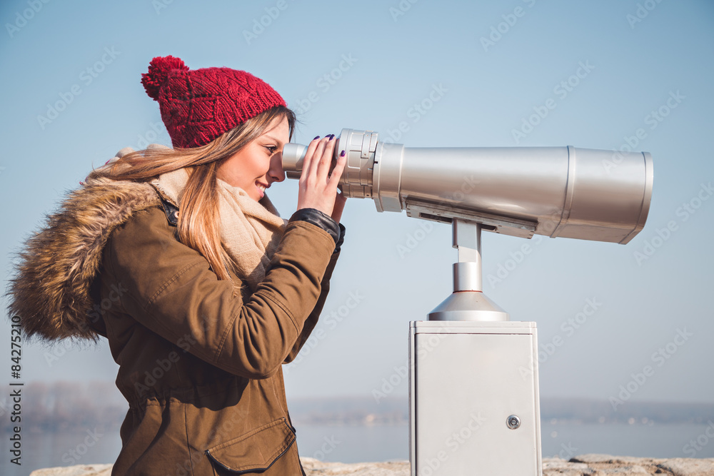 Girl looking through panorama binoculars telescope