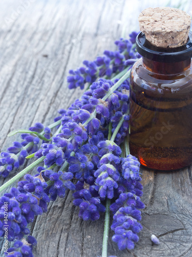 Fototapeta Naklejka Na Ścianę i Meble -  lavender oil with fresh flowers on the wooden table