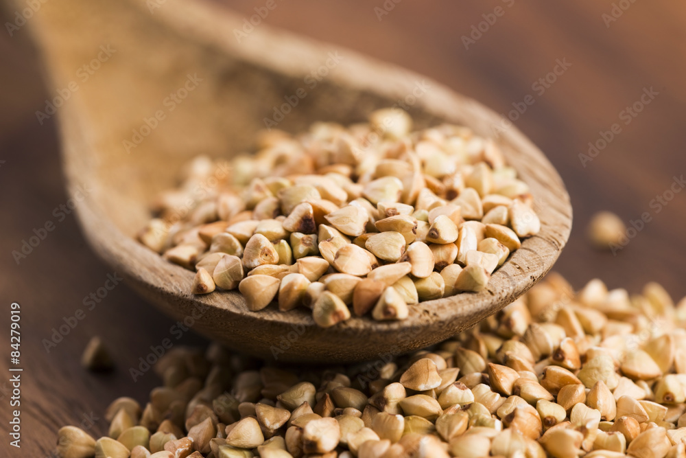 Buckwheat with a spoon on a wooden boards background Buckwheat with a spoon on a wooden boards background