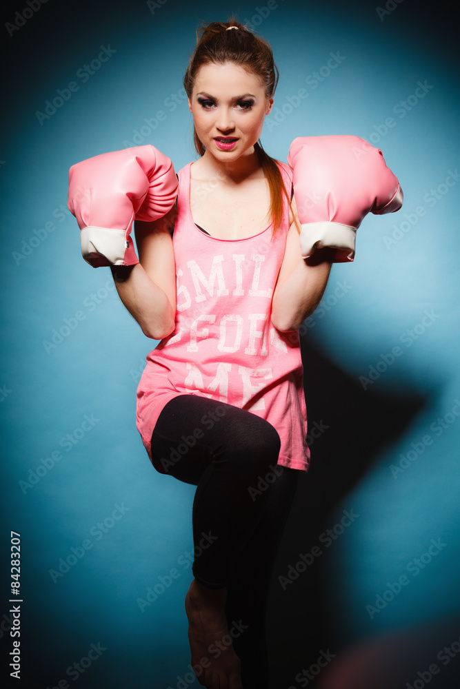 Female boxer wearing big fun pink gloves playing sports