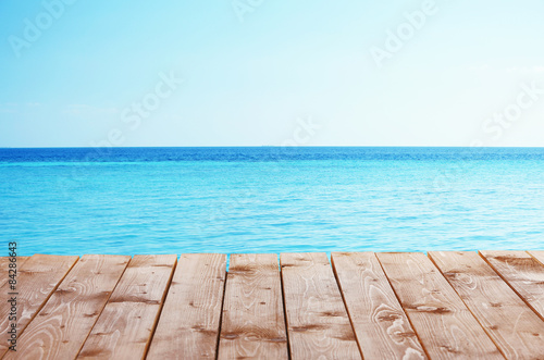 Wooden pier with blue sea and sky background © Africa Studio