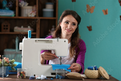 Beautiful young needlewoman in workshop