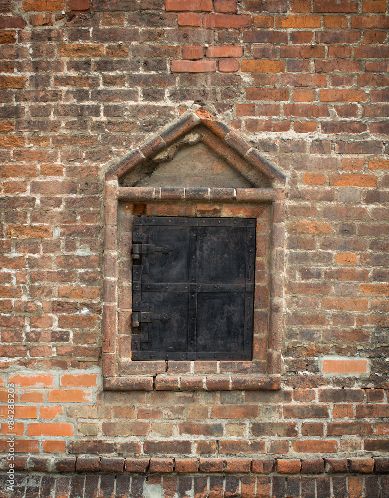 old window in a brick wall, closed metal shutters old window in a brick wall, closed metal shutters