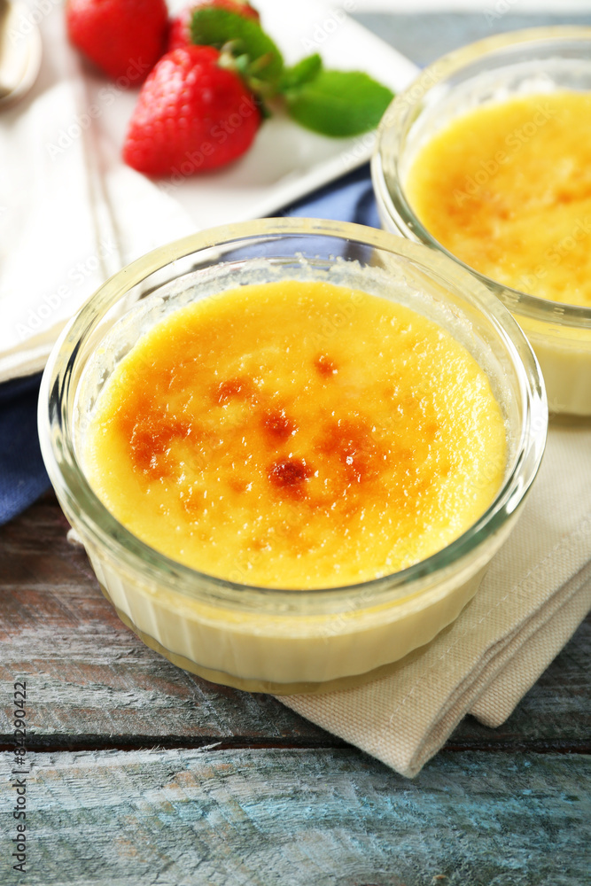 Creme brulee dessert on napkin, on color wooden background Creme brulee dessert on napkin, on color wooden background