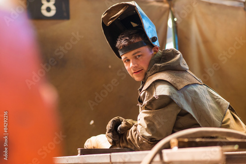 Young man welding inside in a factory
