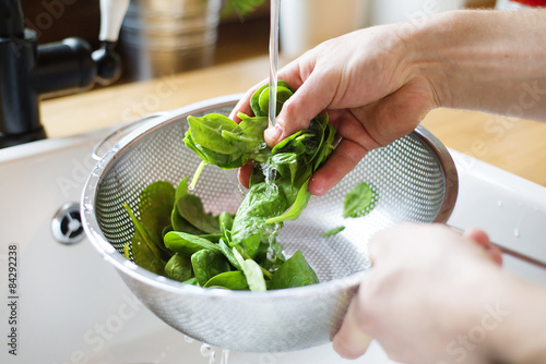 Close up of unrecognizable man washing green salad leaves