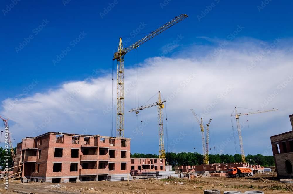 Construction of a small suburban brick house. Construction machi Construction of a small suburban brick house. Construction machi