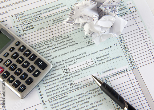 tax papers with crumpled paper, pen and calculator