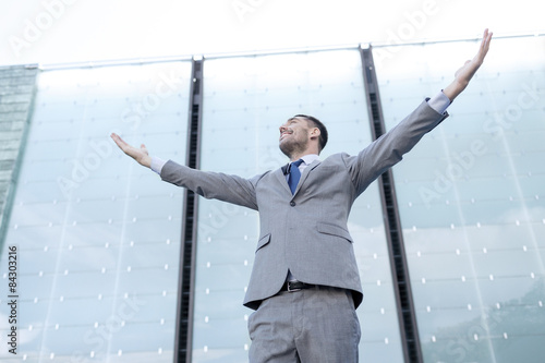 young smiling businessman over office building