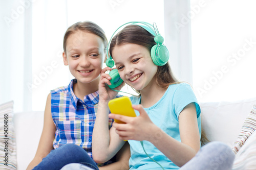 happy girls with smartphone and headphones photo