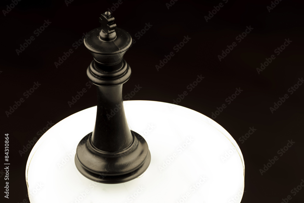 black king of chess on a white glowing circle black king of chess on a white glowing circle