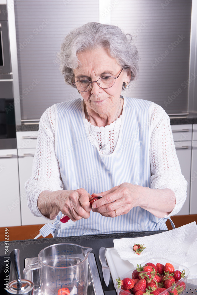 Aktive Seniorin bereitet Erdbeeren vor Aktive Seniorin bereitet Erdbeeren vor