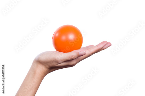 Female hand holding an orange stress ball