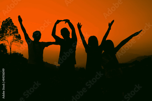 Joyful friends raising hands, silhouette