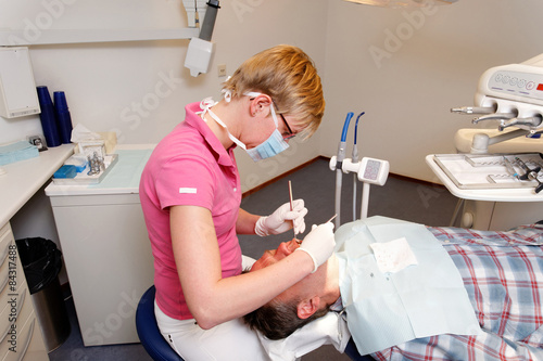 man getting his teeth checked by the dental hygienist