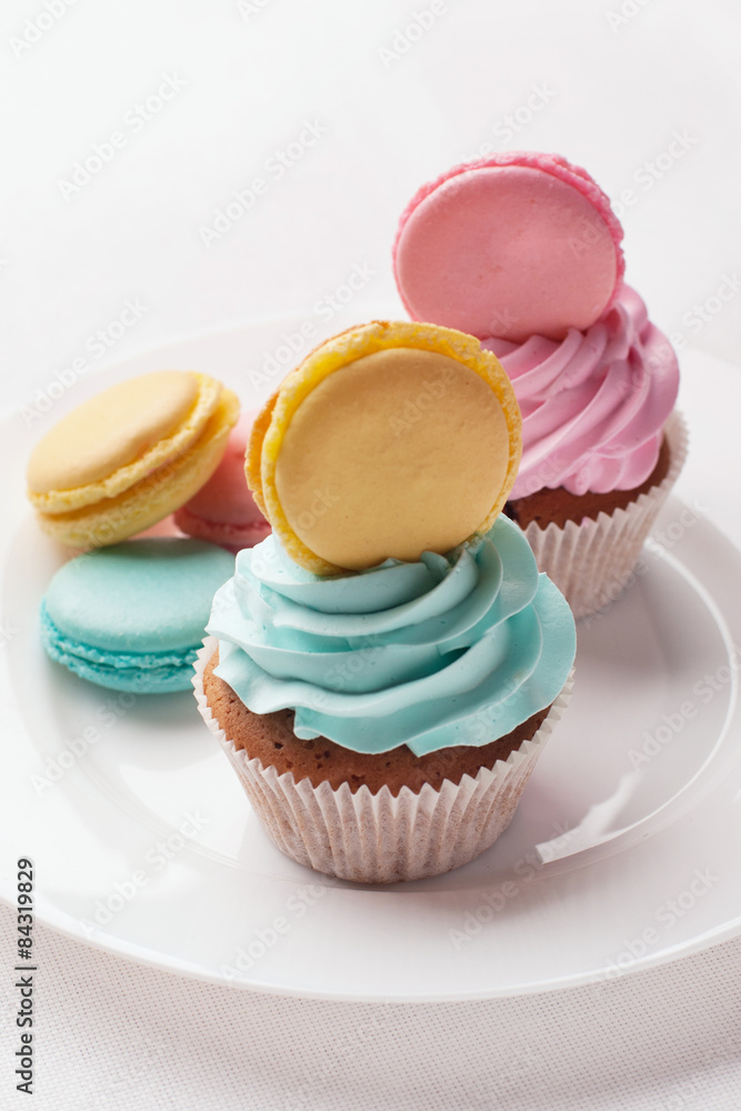 Fototapeta premium Сolorful macaroons with cupcakes and on the plate