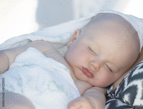 A beautiful baby boy sleeps on the beach in Cancun, Mexico