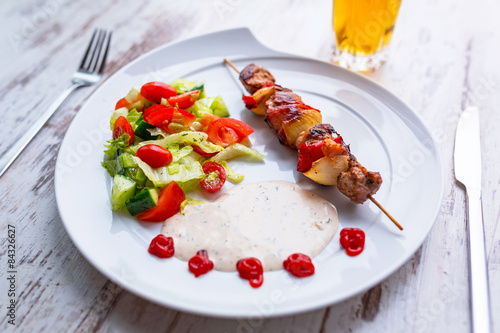 Grilled duck shashlik with salad on the plate