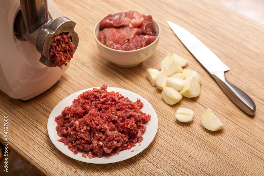 The electric meat grinder, forcemeat, onions and the cut meat The electric meat grinder, forcemeat, onions and the cut meat