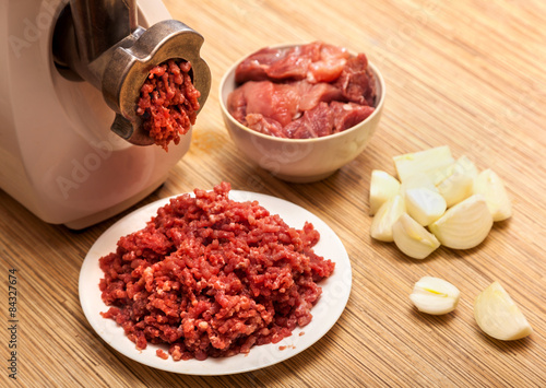 The electric meat grinder, forcemeat, onions and the cut meat