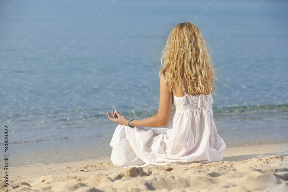 woman meditating and relaxing on beach