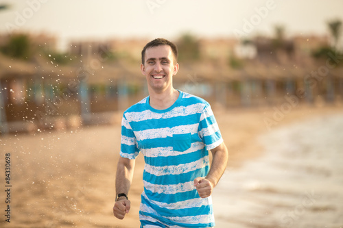 Young man jogging through the surf